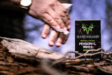 Scent Assassin field wipes with a background showing a close-up of a hand wiping the other hand with field wipes.