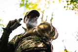 a man putting scent control spray on his body while dressed in hunting clothes