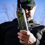 a close-up of a bottle of hunting body wash and shampoo with a hunter holding it in the background