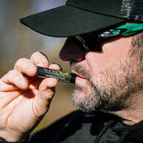 Close-up of a hunter applying hunting lip balm to his lips.