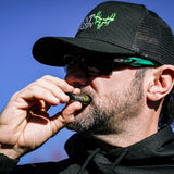 Close-up of a hunter applying Scent Assassin hunting lip balm to his lips.