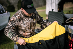 a hunter prepping his hunting gear while wearing a hunting hat