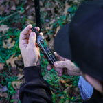a man holding and looking at a 4oz scent control spray