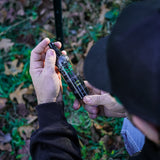 a man holding and looking at a 4oz scent control spray