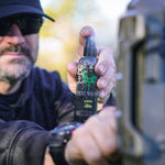 a man holding and spraying 4oz scent control spray